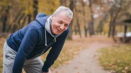 Older adult stretching during an outdoor walk in a park