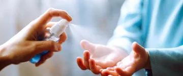 cleaning hands with hygiene spray