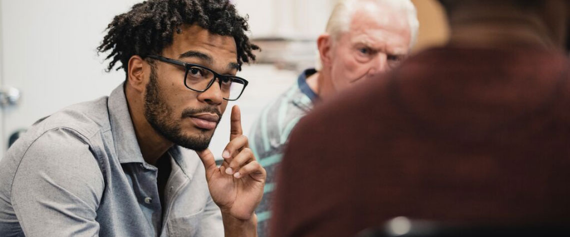 man with glasses raising finger