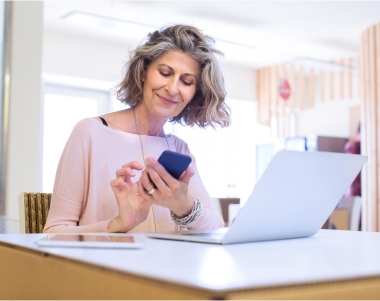 woman-smiling-and-using-mobile-phone