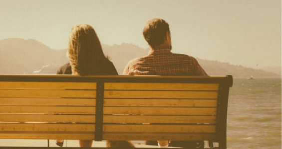 A couple in a relationship sitting on a bench
