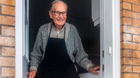 An elderly man opening his front door during the coronavirus lockdown