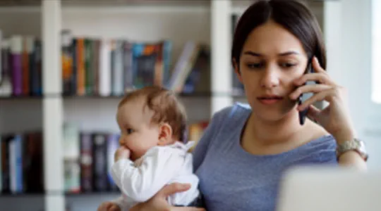 mother talking on phone and holding her baby 