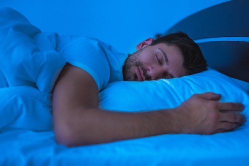 Man asleep with blue lighting behind