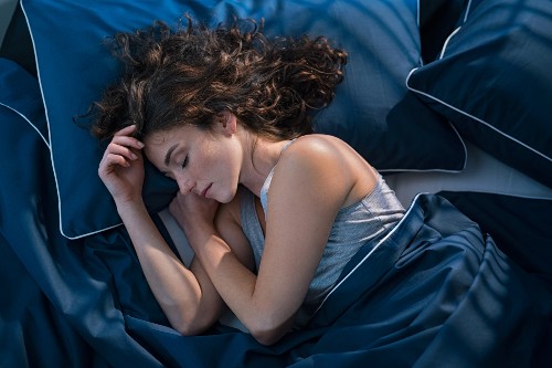 Woman asleep on blue pillows