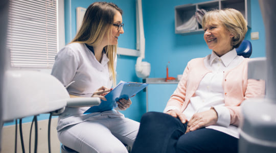 Woman in a dentist’s surgery talking to her dentist about having a filling. 