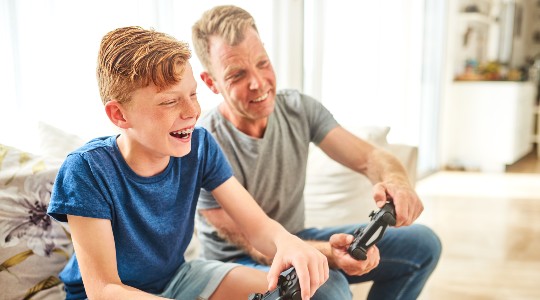 Father and son wearing braces, playing on a games console