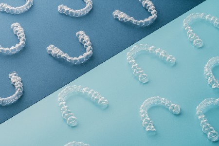 Invisalign aligners laid out on a blue background