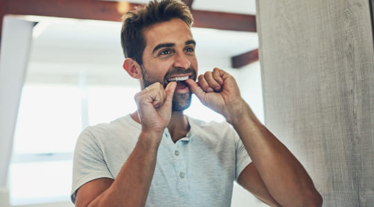 Man flossing in mirror