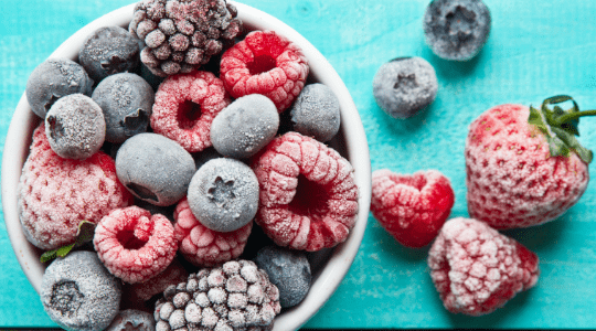 Large bowl of plain porridge with blueberries in background