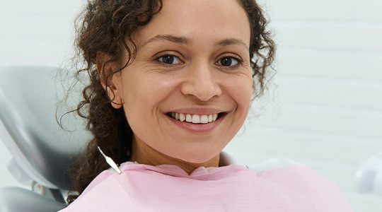 Smiling lady on a dentist chair looking relaxed