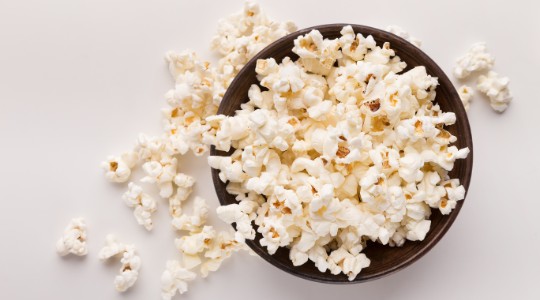 Bowl of plain popcorn in a brown bowl