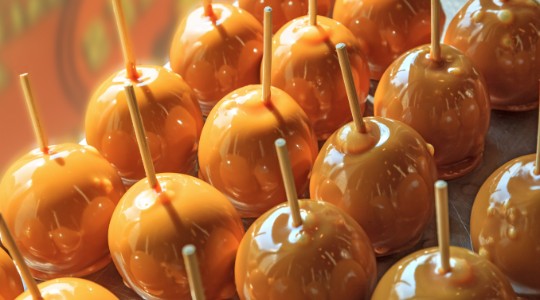 Rows of glazed toffee apples on sticks