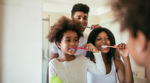 Family brushing teeth at sink