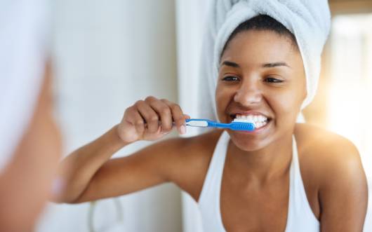 Person brushing teeth while looking in the mirror