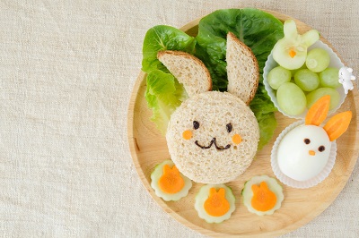 sandwich cut into the shape of a bunny with a side of egg, spinach and grapes