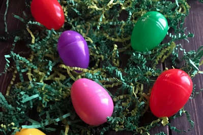 coloured plastic eggs on cut-up green paper