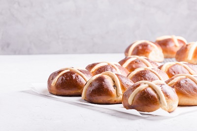a selection of hot cross buns sitting on white napkins