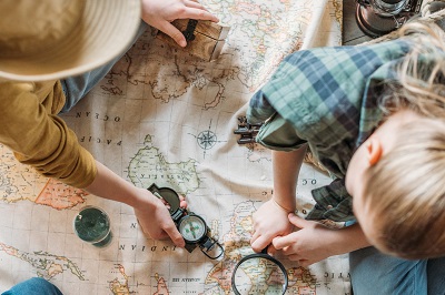 kids looking at a map and compass