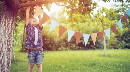 Boy hanging up bunting in the garden