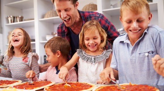 Happy smiling family cooking pizza at home 