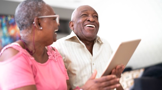 Man and woman laughing with iPad 