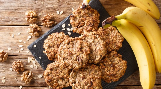 Banana oat cookies next to fresh bananas