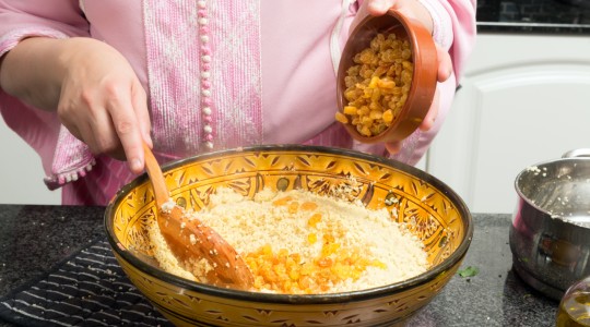 Woman adding sultanas to couscous