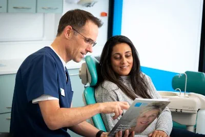 Dentist speaking to patient in chair