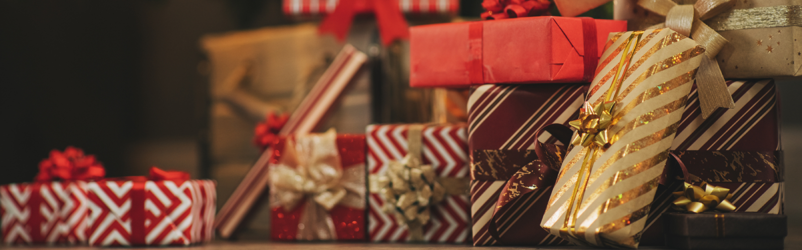 Many wrapped Christmas presents pilled under a tree