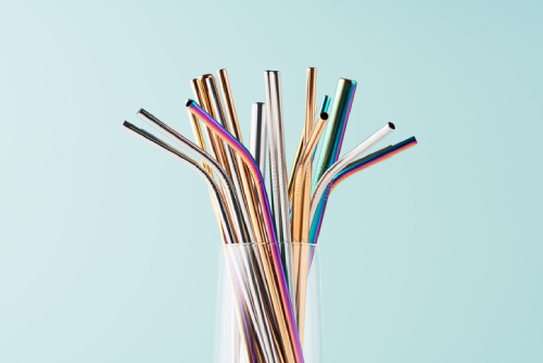 A bunch of reusable metal straws in a glass