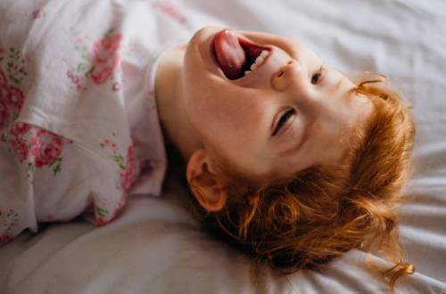 Child lying down in bed