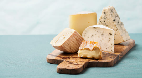 a selection of cheeses on a marble board  