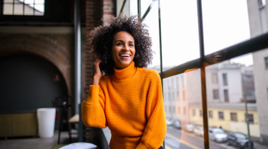 Photo of a smiling woman sitting by a window