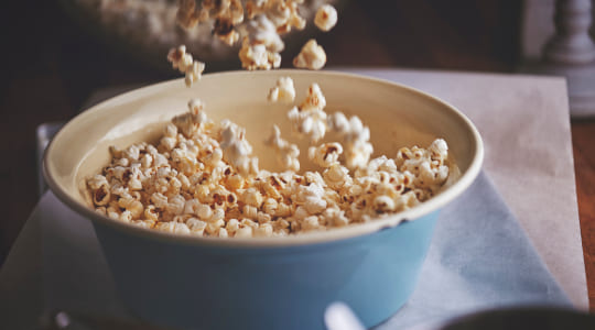 Popcorn being poured into a bowl