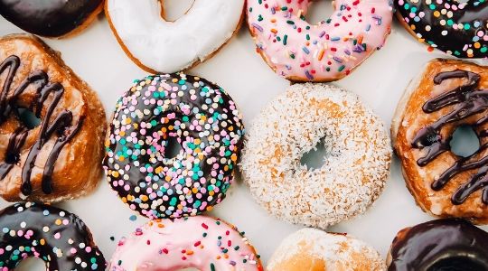 Colourful glazed ring donuts with sprinkles