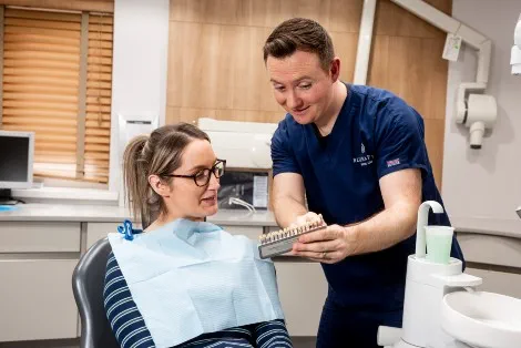 Dentist speaking to a patient in the chair