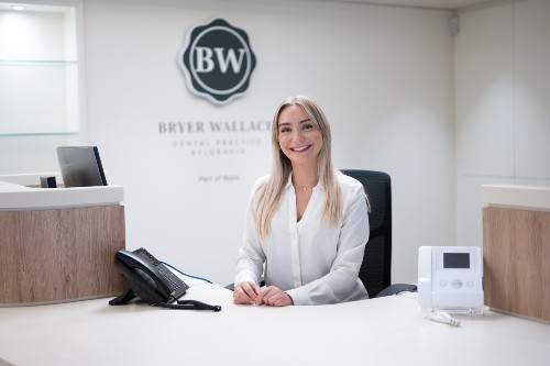 Bryer Wallace, Belgravia Bupa dentist smiley receptions at her desk.