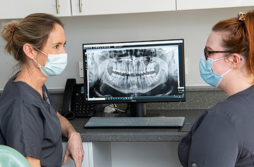 Dentist and nurse looking at scan on a computer at Moreton Dental Care