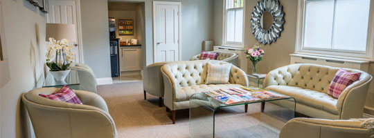 The comfortable patient lounge at the raglan suite with plush white sofas and magazines