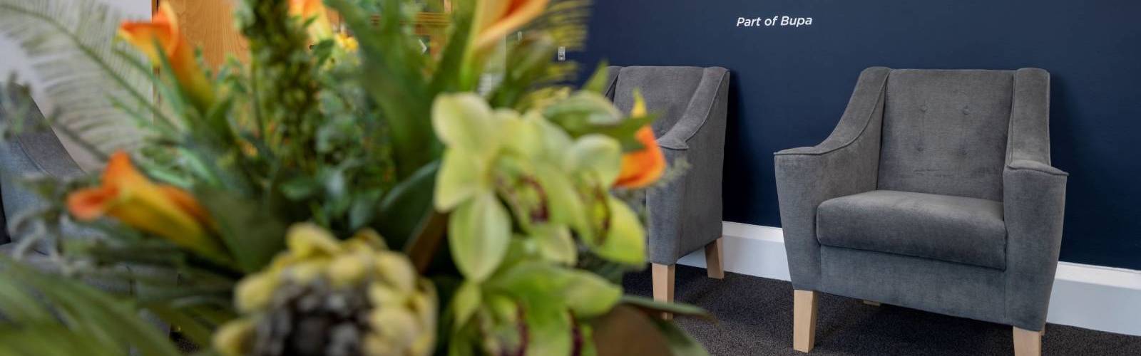Comfortable arm chairs with grey velvet and fresh flowers