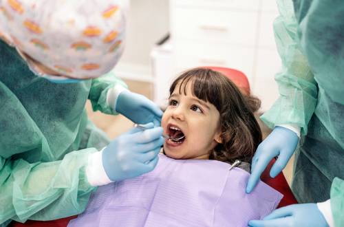 A little girl having her teeth examined by a dentist
