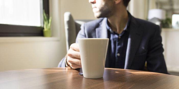 Image of a man drinking tea and looking out of the window
