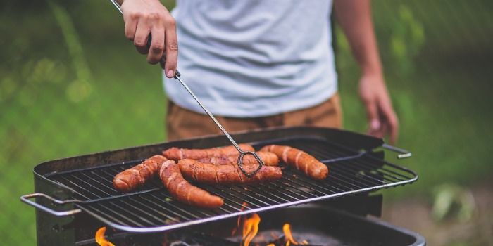 Picture of a man cooking sausages on the barbeque