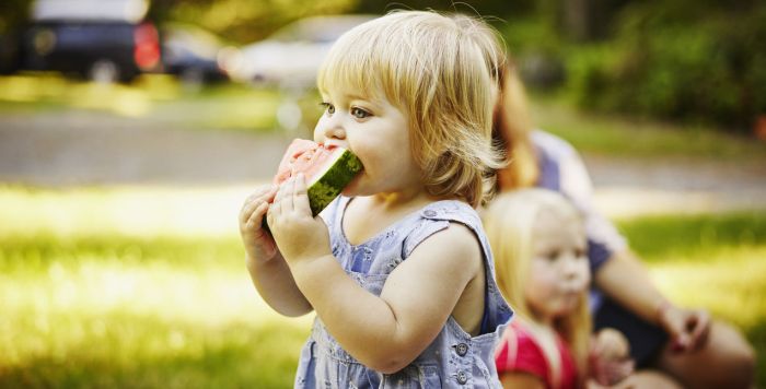 Young girl eating a slice of watermelon