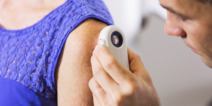 Image of dermatologist examining ladies skin.