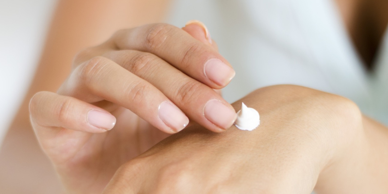 Image of a woman's hands, applying moisturiser