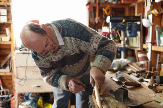 Older man carving at a workbench