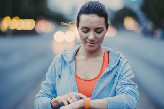 A female runner sets her watch