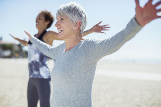Two ladies strectching, doing yoga at the beach
